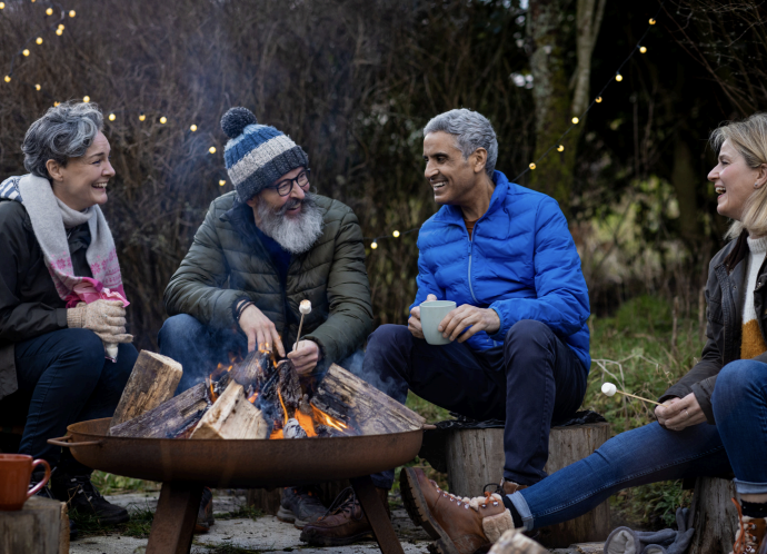 four people around a fire pit